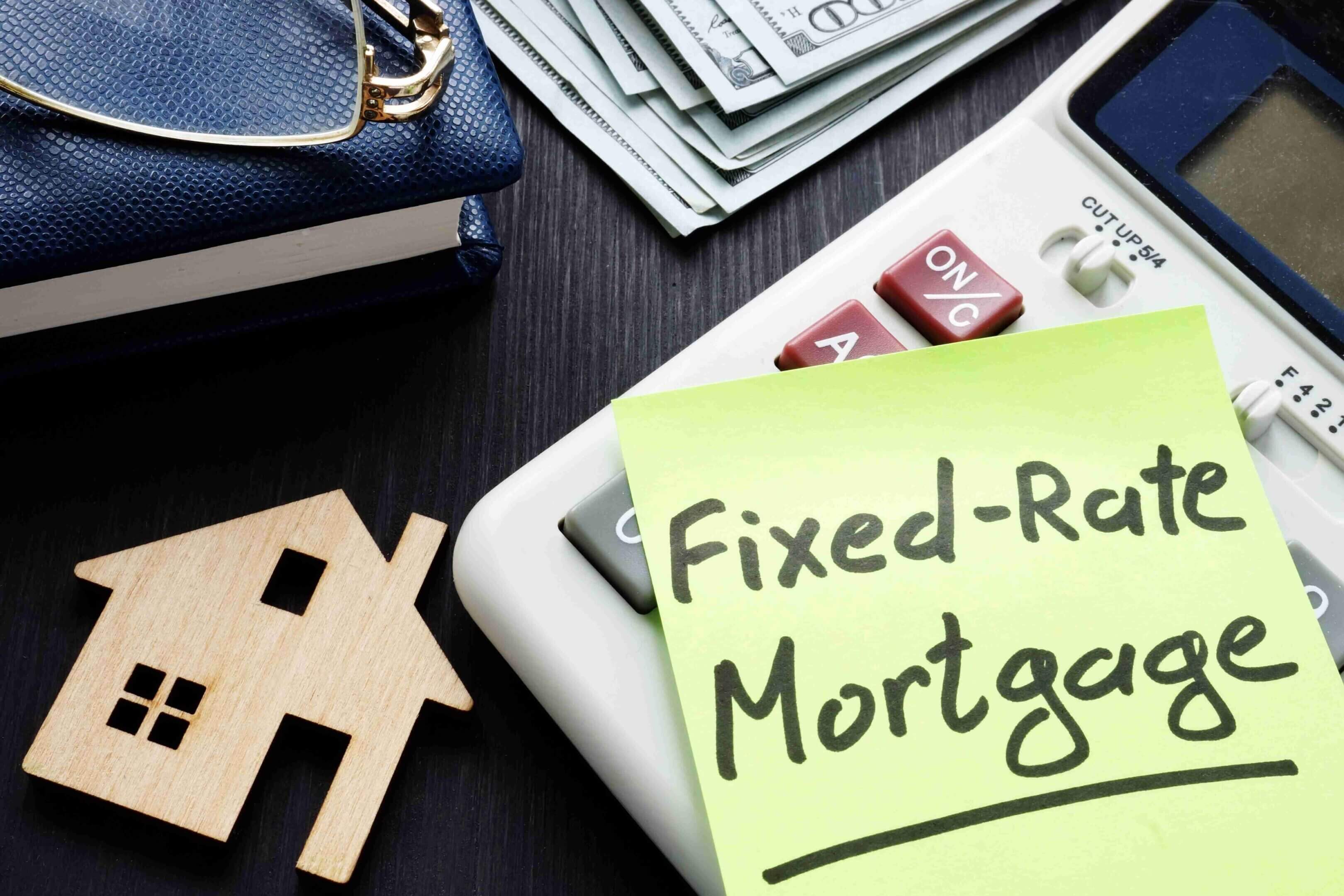 Sticky note labeled "Fixed-Rate Mortgage" next to a house cutout and cash.