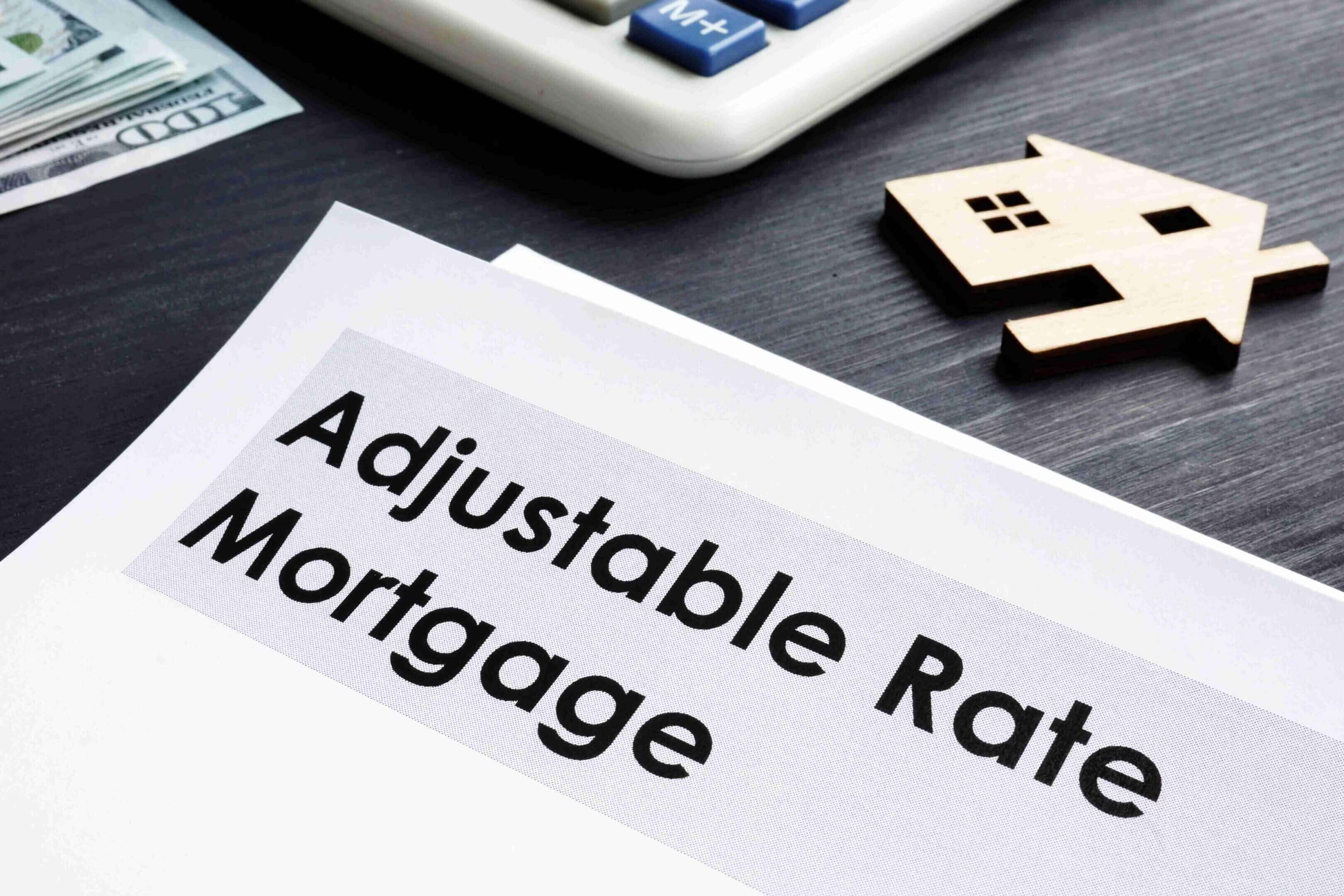 Documents titled 'Adjustable Rate Mortgage' on a desk with house-shaped tokens.