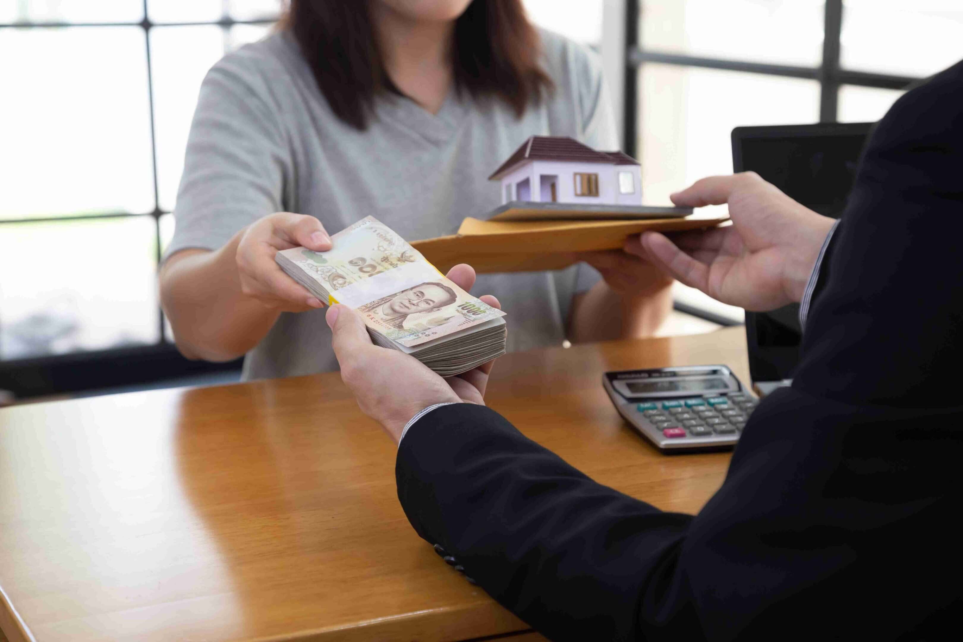 Person handing over cash while receiving house keys.