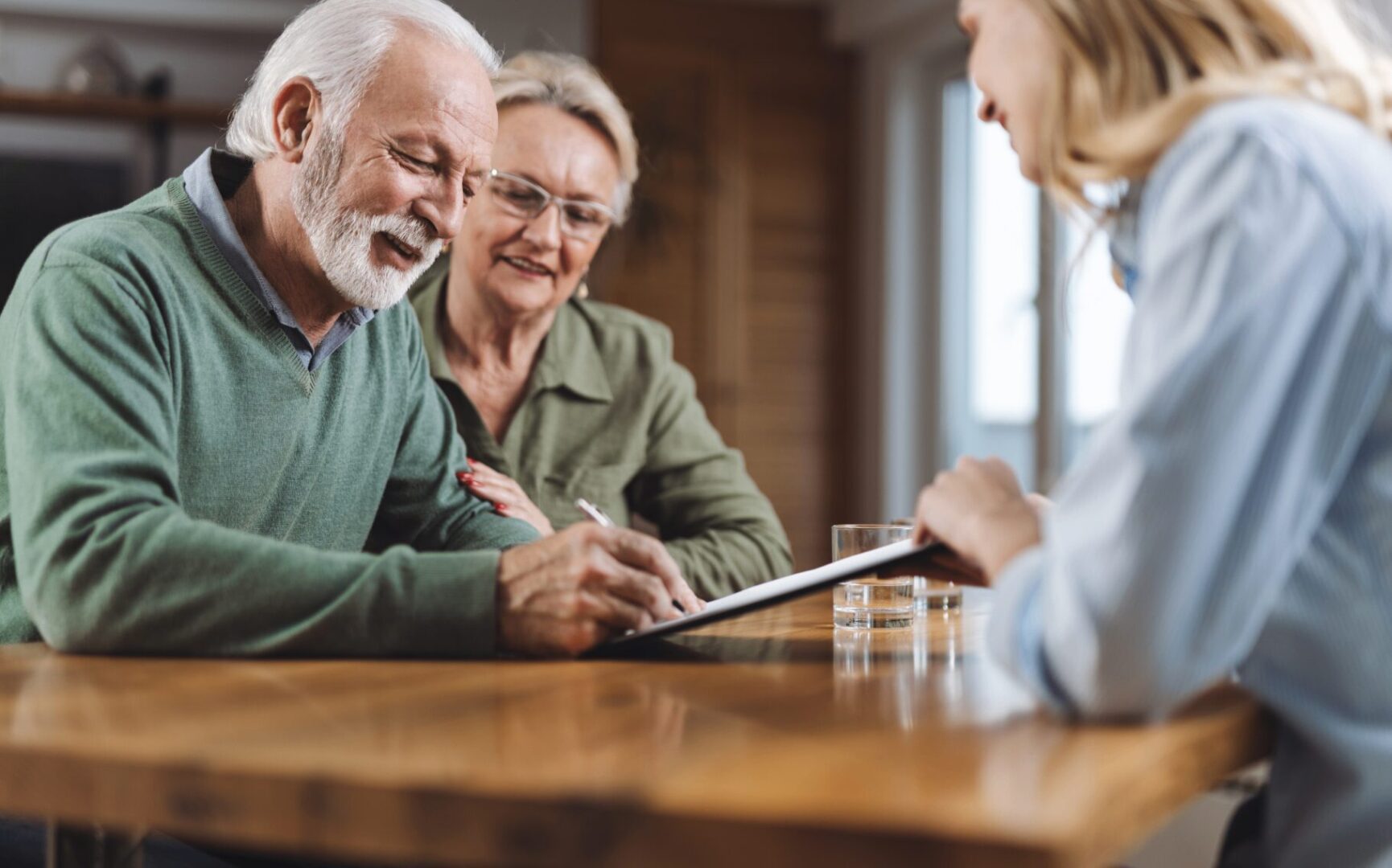 Senior couple discussing documents with a professional at a table.